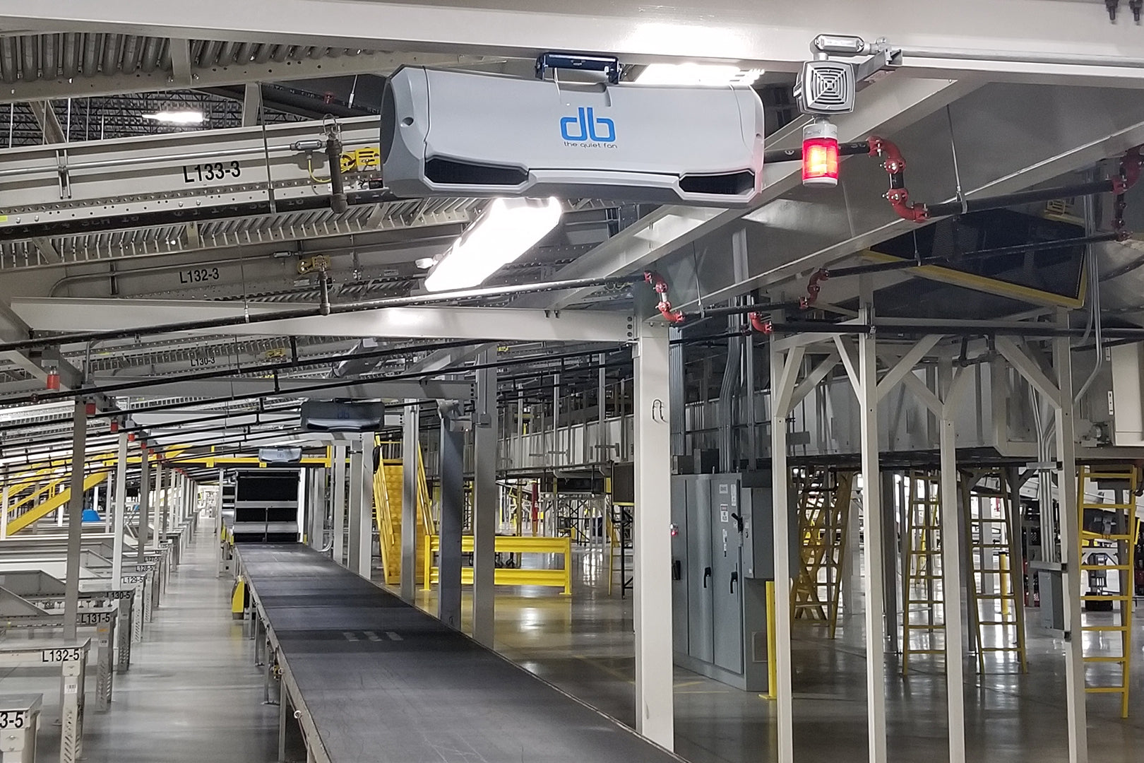 db quiet industrial fan mounted above conveyor system in a distribution center for improved airflow