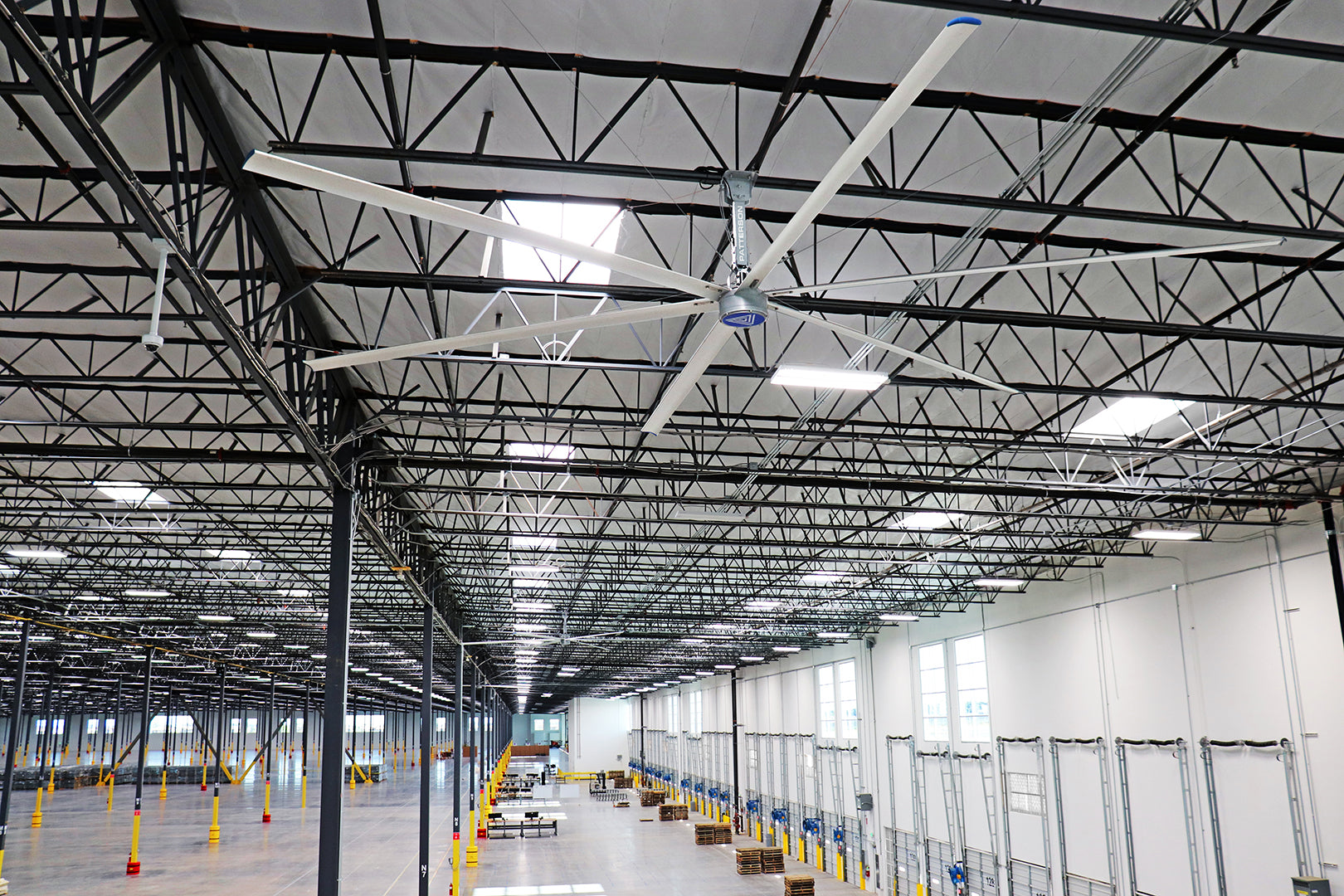 Large HVLS industrial ceiling fan installed in a spacious warehouse facility