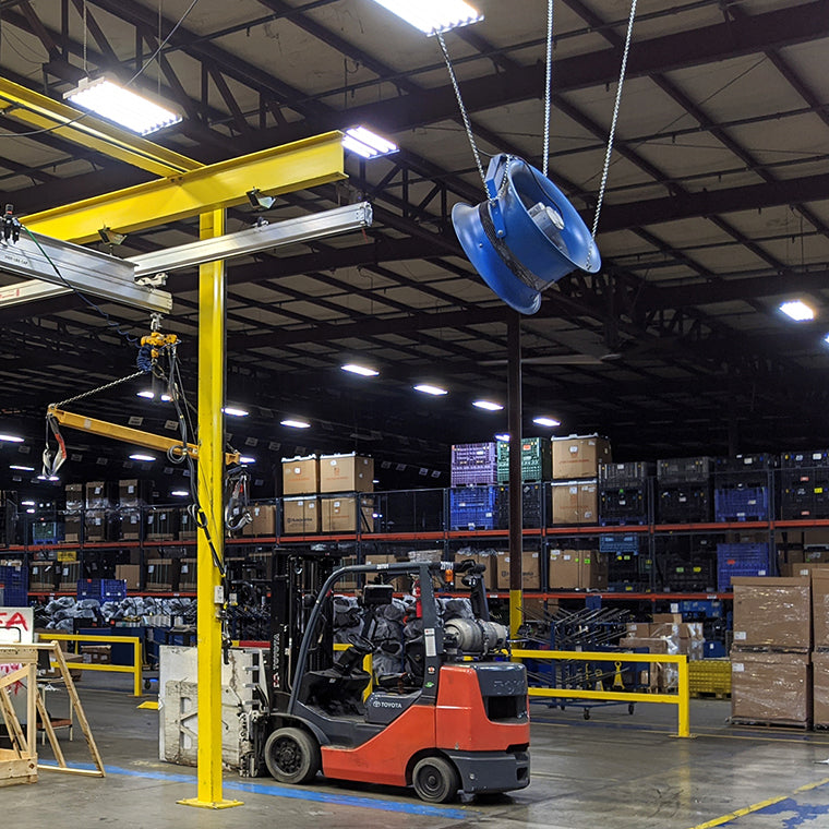 Warehouse interior with forklift and chain suspended cooling fan by Patterson.