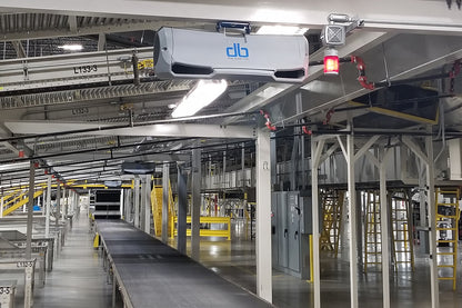 db quiet industrial fan mounted above conveyor system in a distribution center for improved airflow