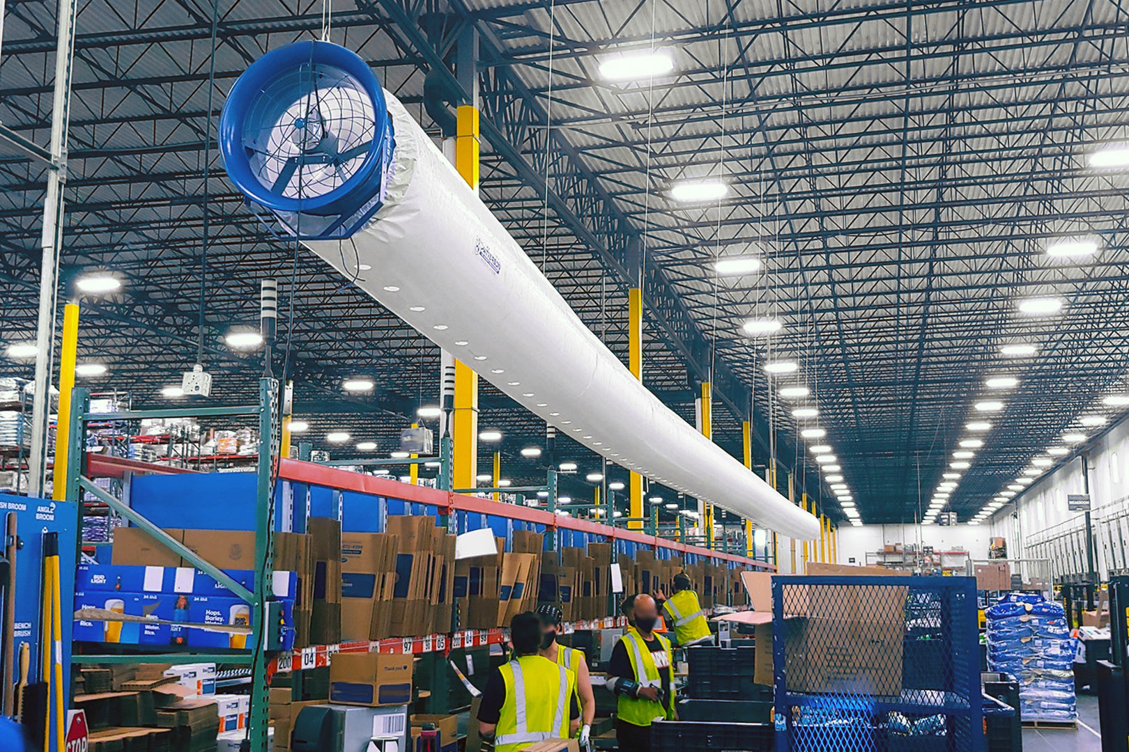 High-velocity fabric duct fan system providing overhead cooling in a large warehouse facility