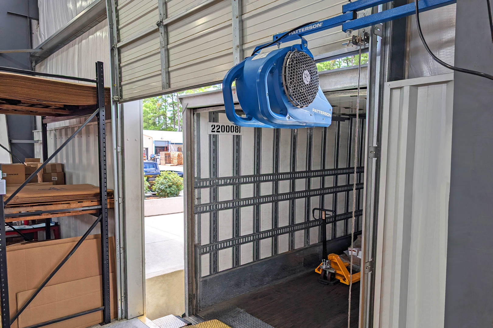 Patterson loading dock door fan mounted above an open dock doorway for improved warehouse airflow