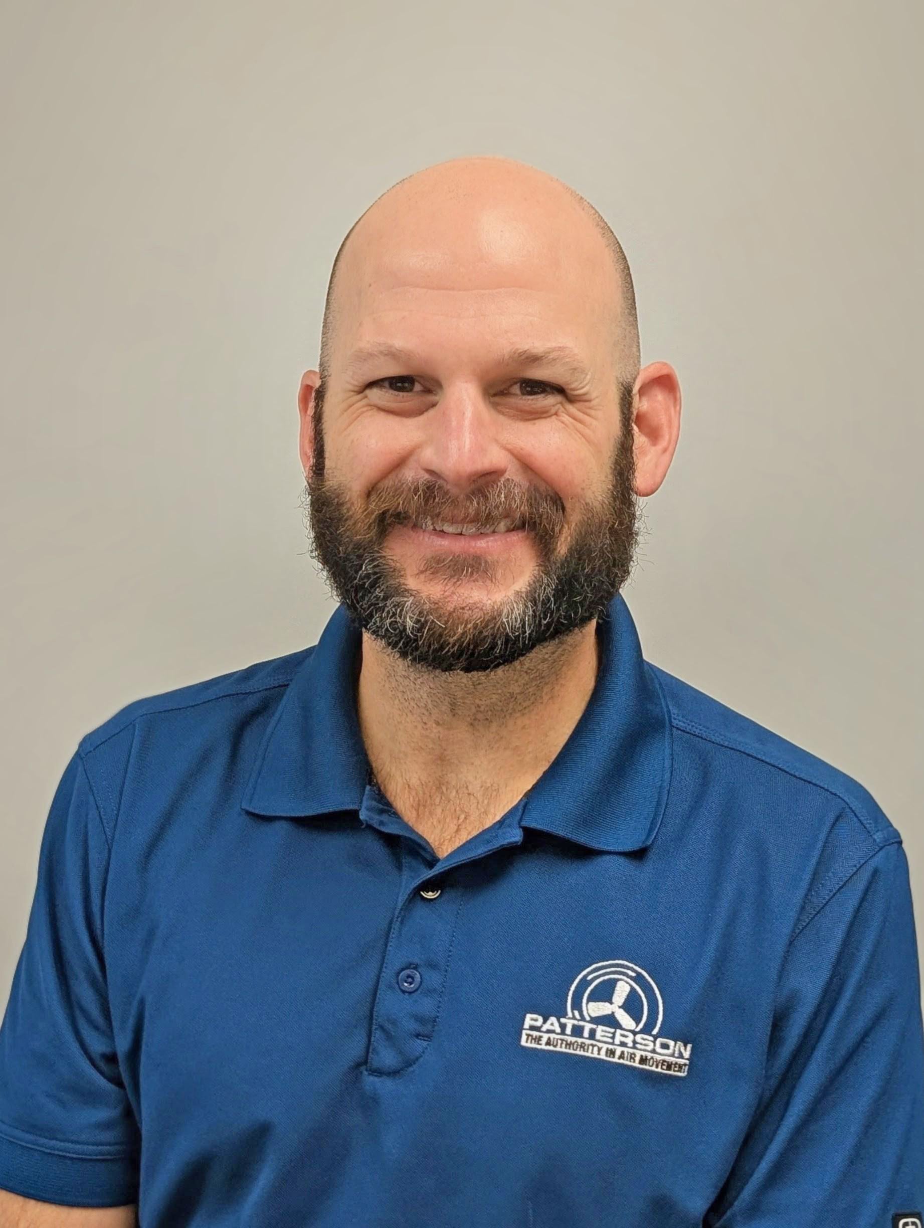 Professional headshot of a man wearing a Patterson-branded polo