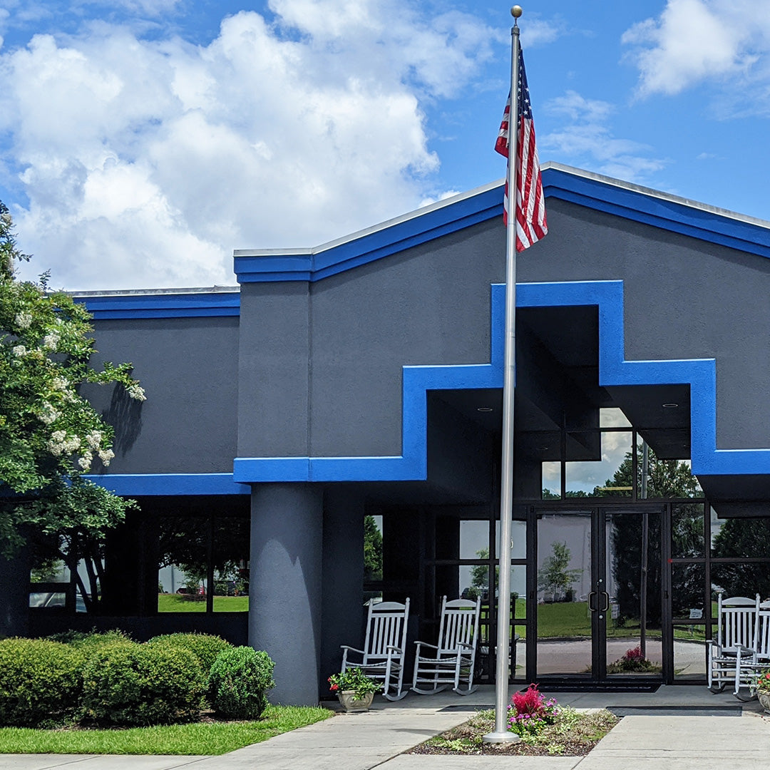 Exterior of the Patterson Fan corporate headquarters with blue trim and an American flag at the entrance