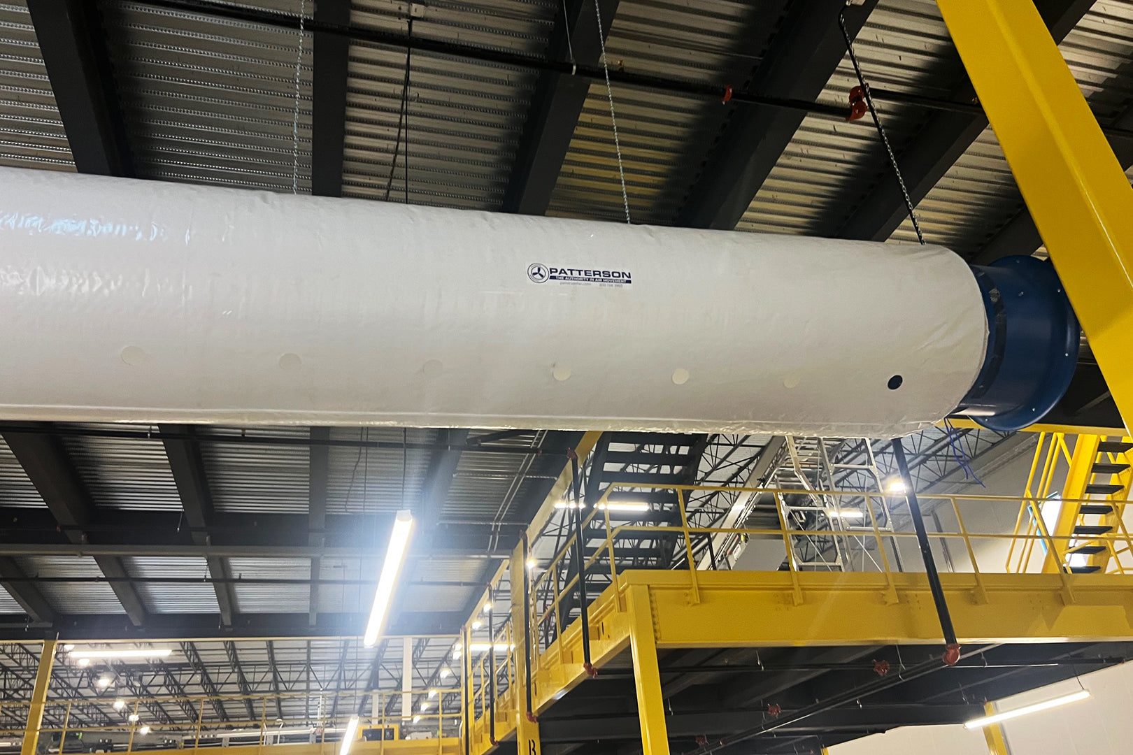 Fabric air duct power tube suspended from the ceiling in a warehouse for industrial cooling