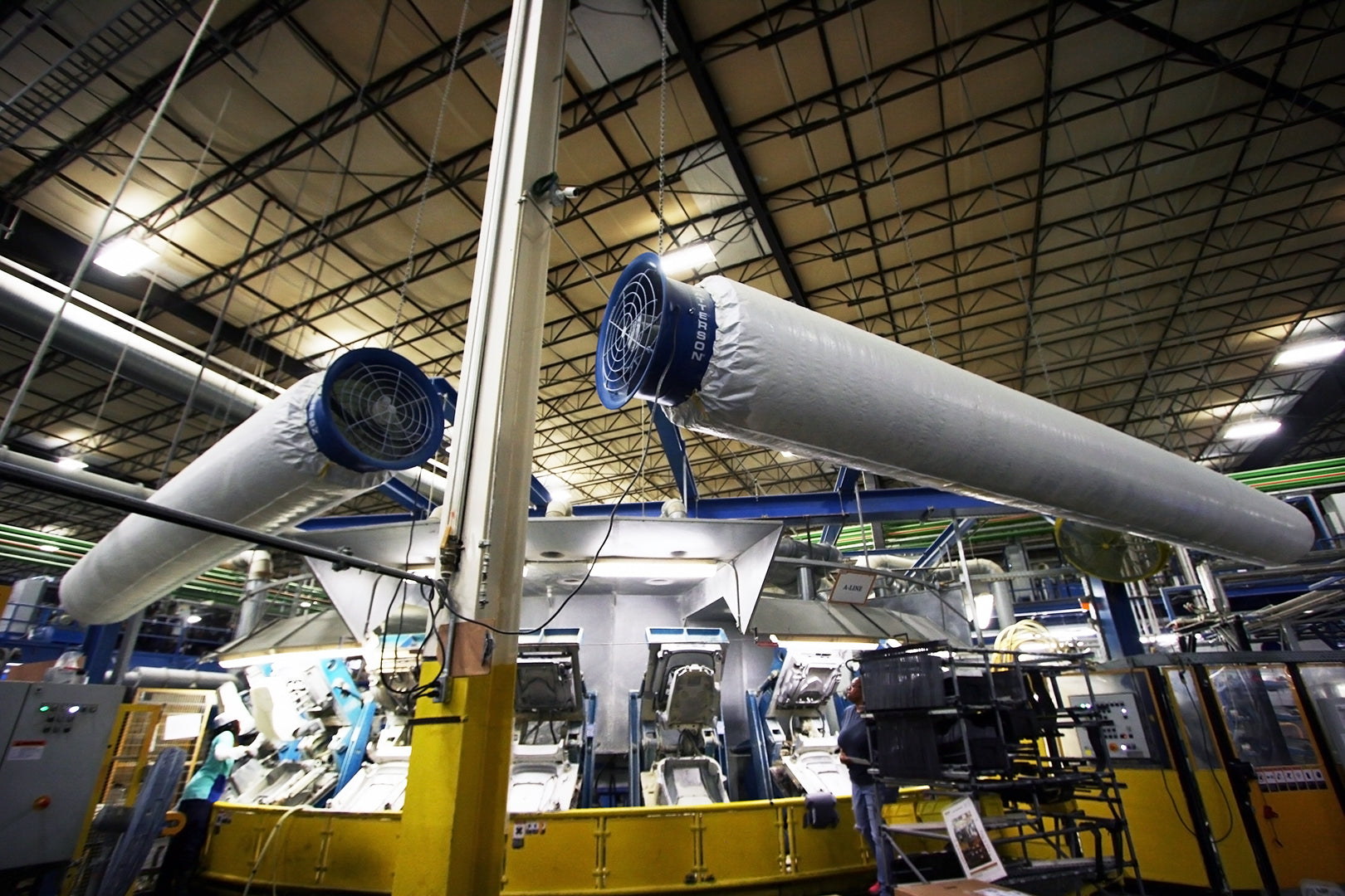 Patterson blower fans with long fabric air distribution tubes providing airflow in an industrial manufacturing facility