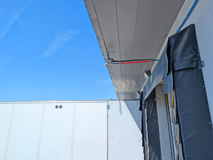 Mounted overhead evaporative truck cooler installed above a truck dock canopy