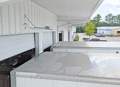 Spray evaporative truck cooler unit mounted above truck trailer bays to reduce heat during loading operations