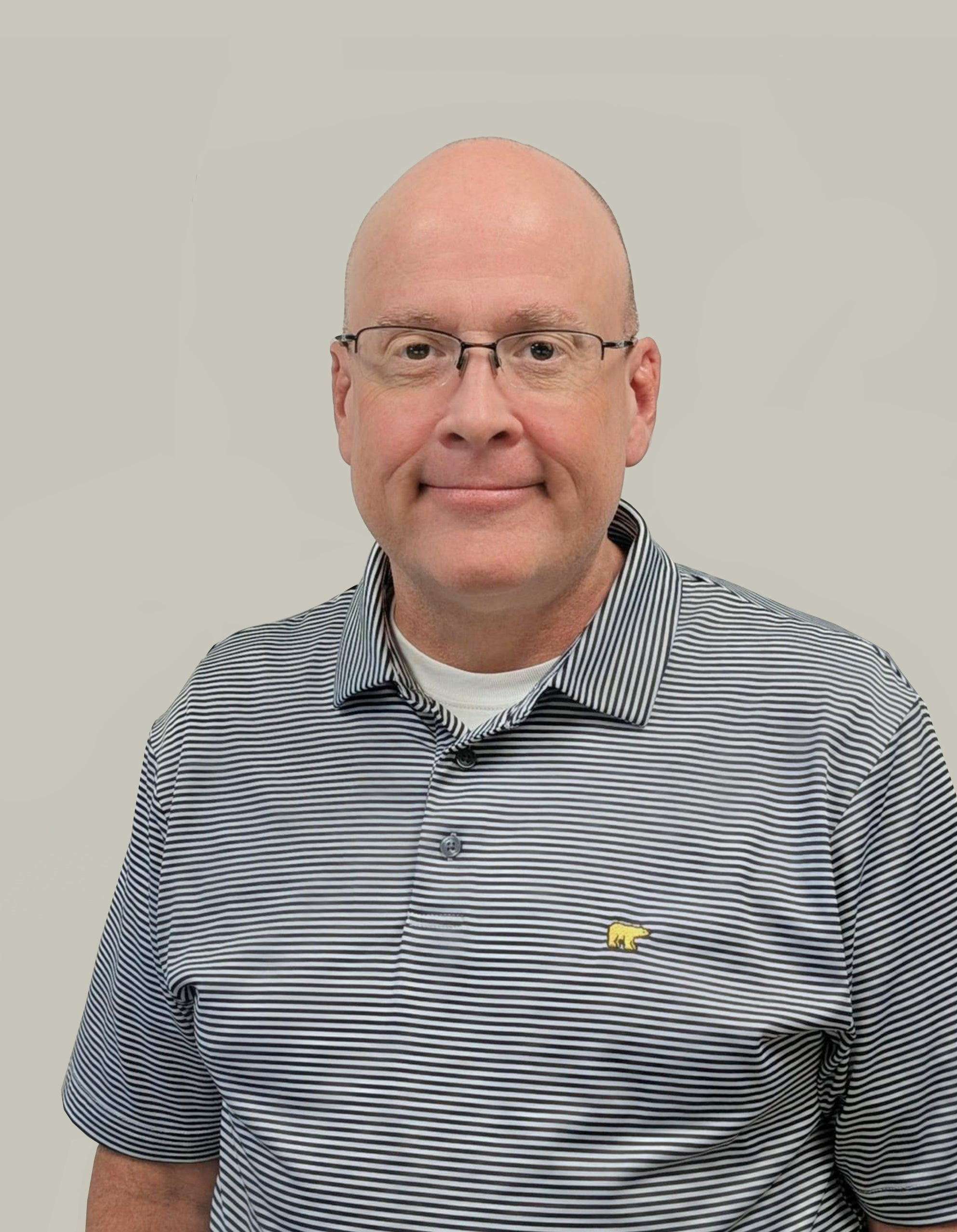 Professional portrait of a man wearing glasses and a striped polo