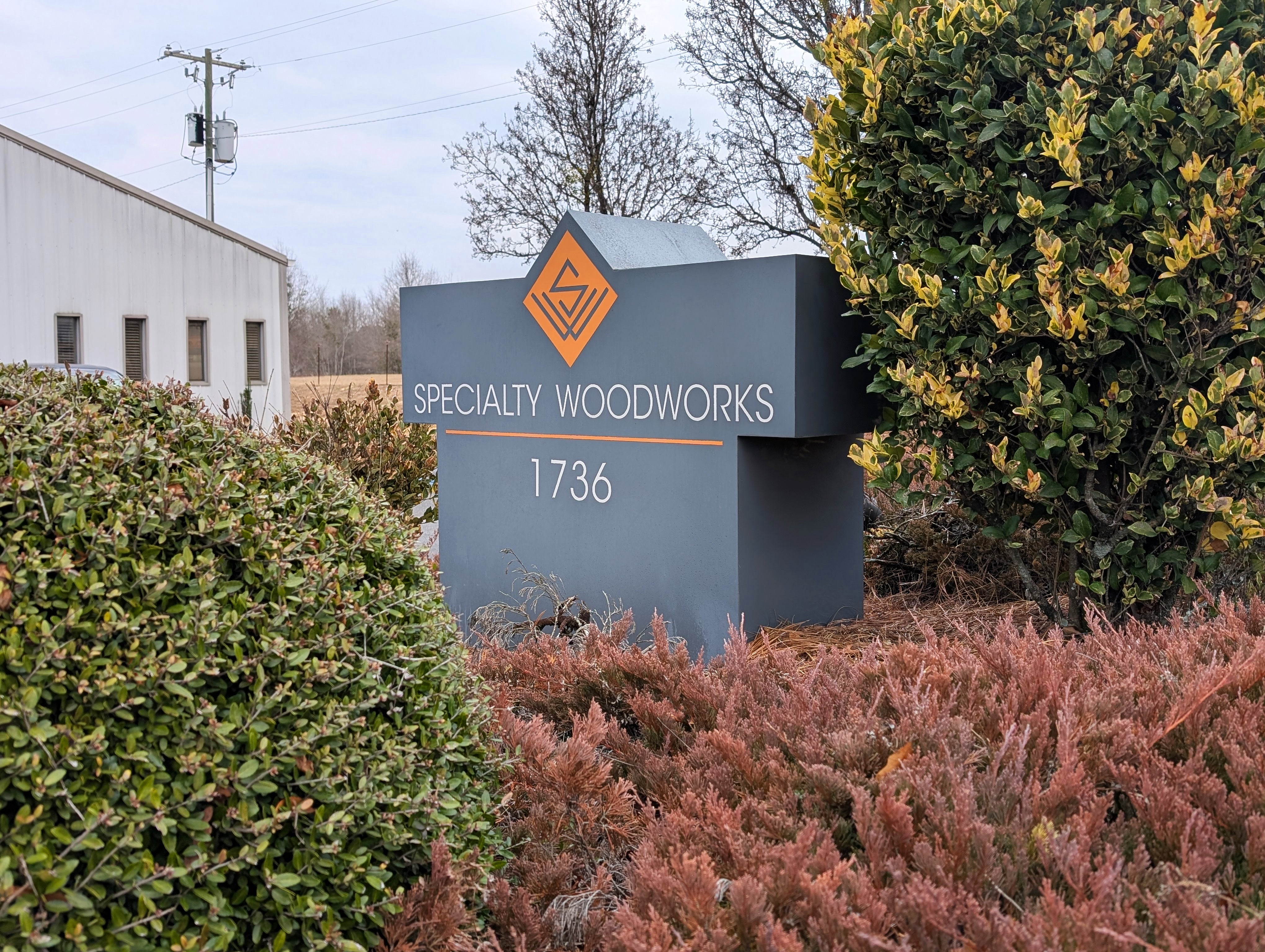 Specialty Woodworks exterior sign surrounding by landscaping at the company's facility