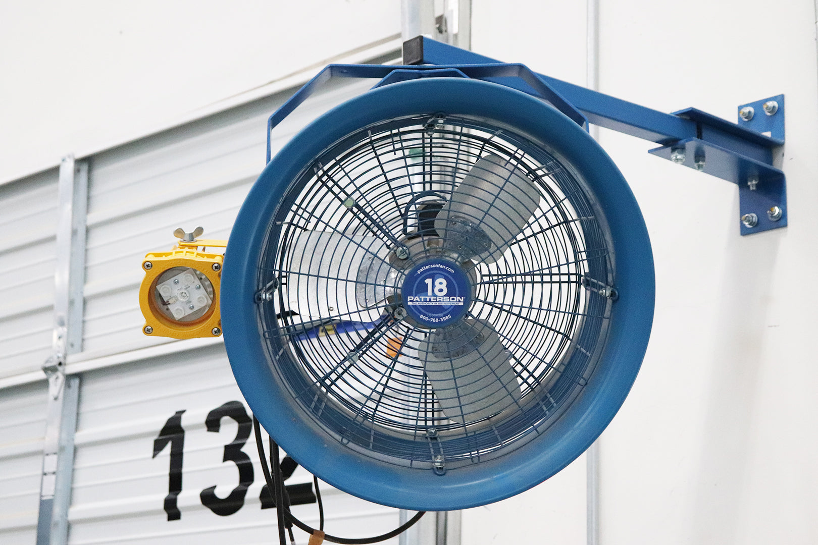 18-inch Patterson industrial wall-mounted fan on blue adjustable bracket