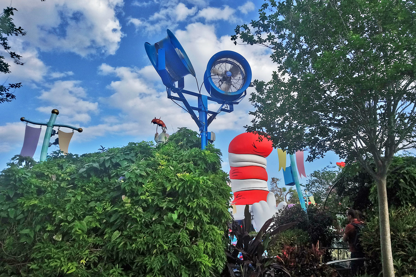 Large outdoor blue industrial fan mounted on a tall pole at a theme park