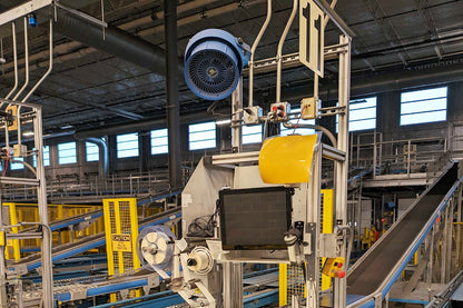 Patterson 10-inch industrial fan mounted above a conveyor system in a warehouse facility