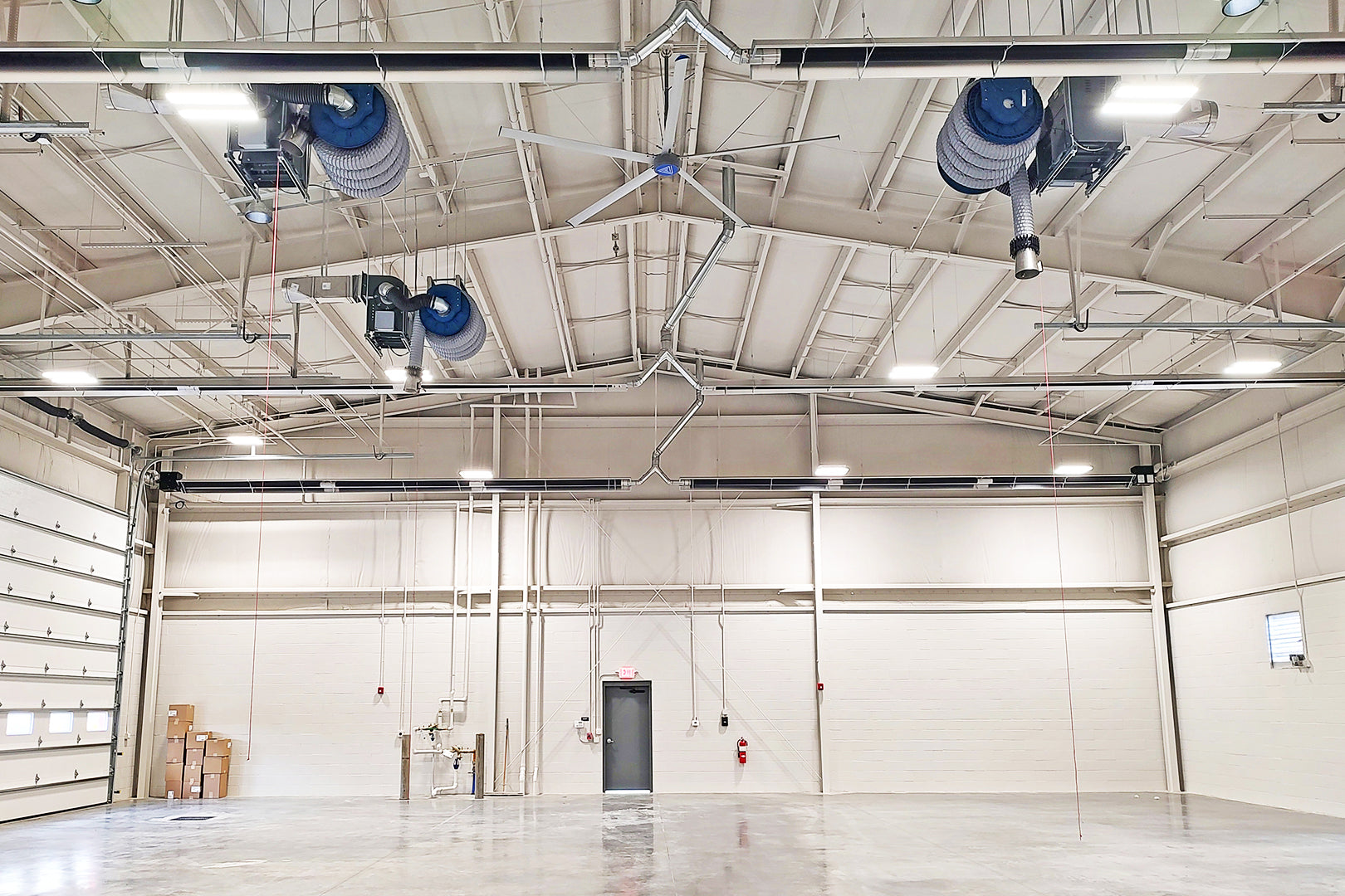 Industrial HVLS ceiling fan and ventilation fans installed in an empty waste management facility